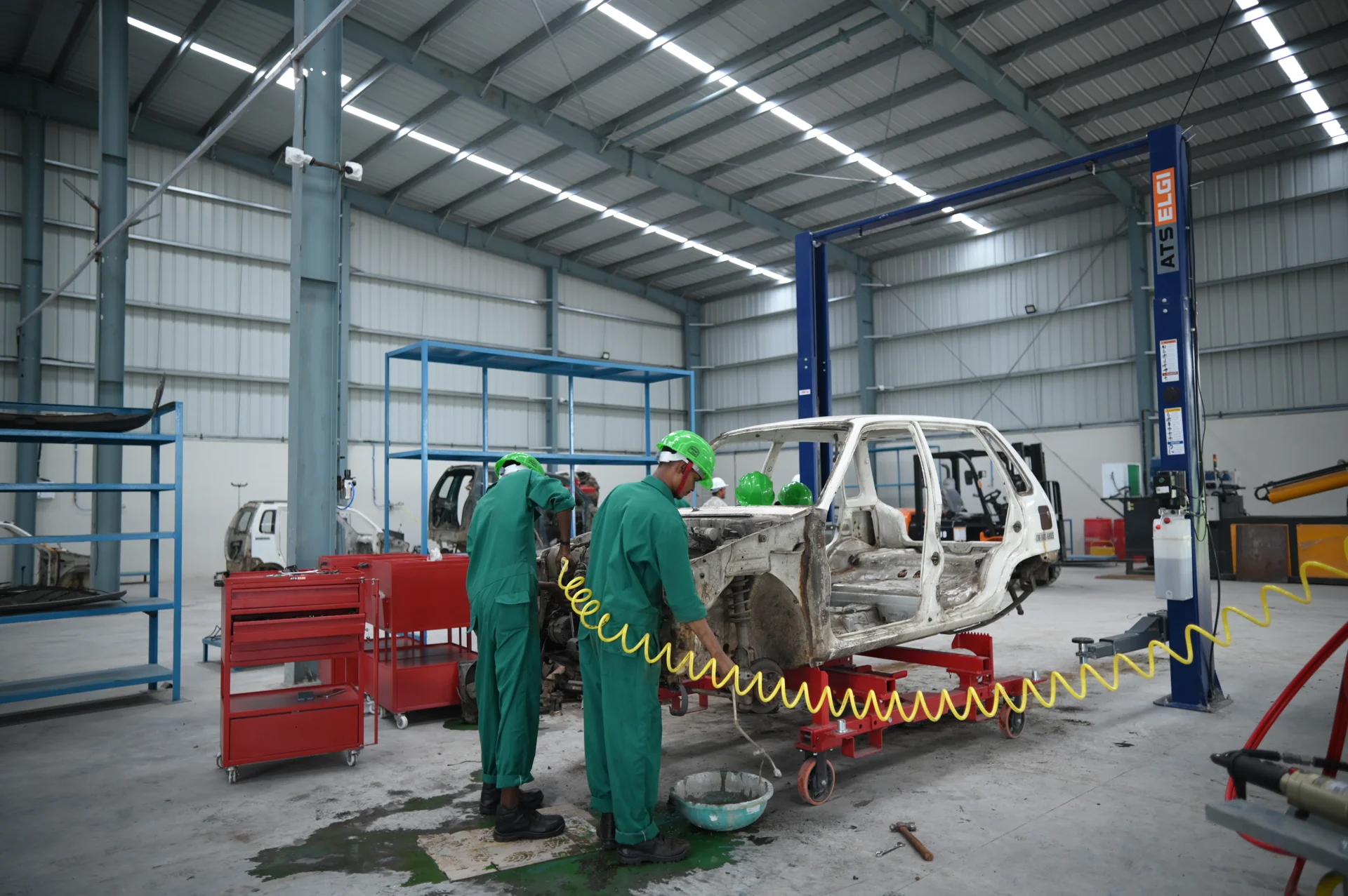 Team members working on a vehicle body inside the facility
